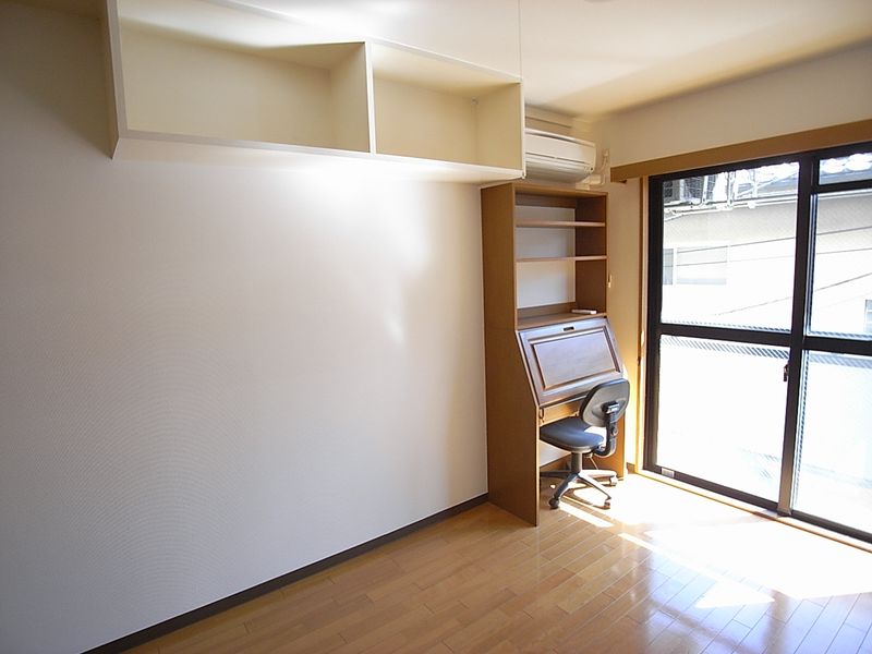 居室（Aタイプ）　机は備え付き、吊棚もあります。　※窓側の写真