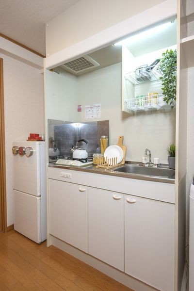 キッチン（Aタイプ）　1口ガスコンロ、シンクの横にまな板を置けるスペースがあります。※モデルルームのため小物はつきません