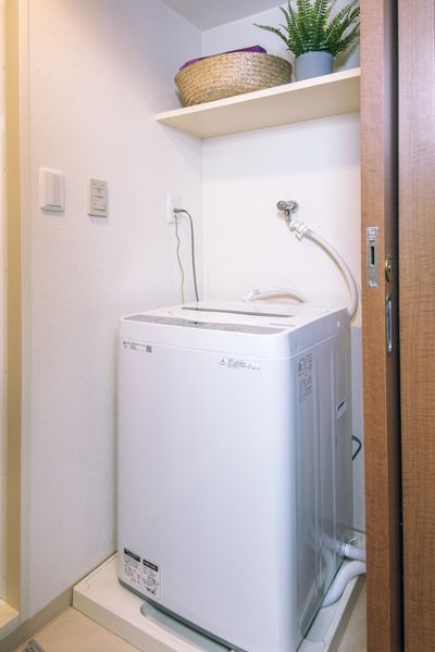 室内洗濯機置き場（Aタイプ）　洗濯機置き場の上に上部棚があり、収納に便利です。※モデルルームのため小物は付きません